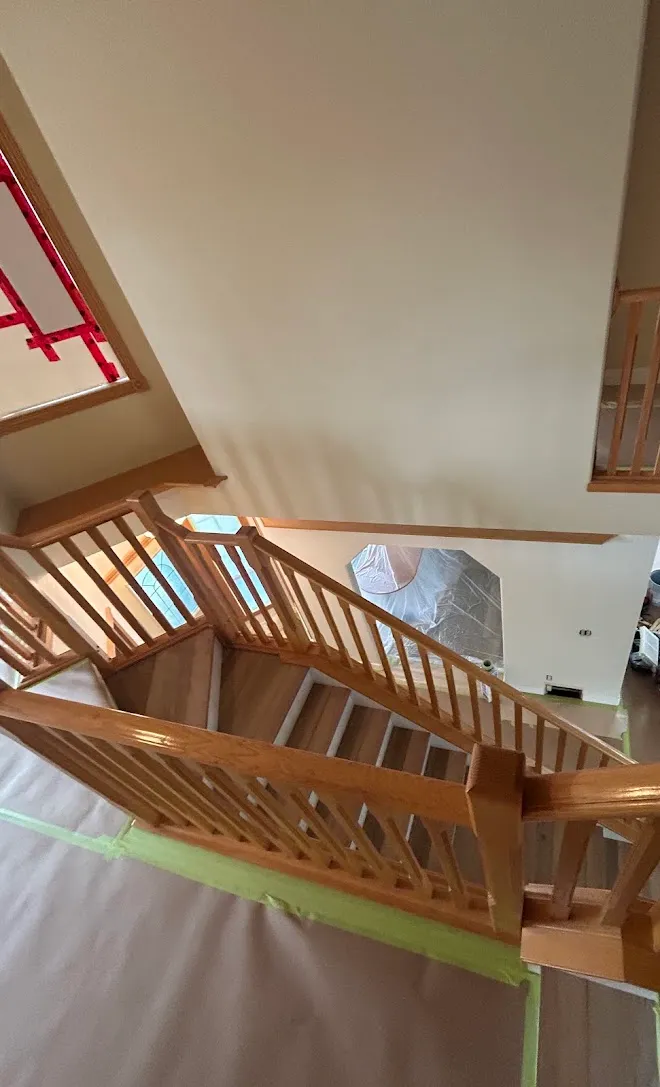 Repainted stairwell with crisp lines along the railing — Leonard’s Painting, Edmonton area