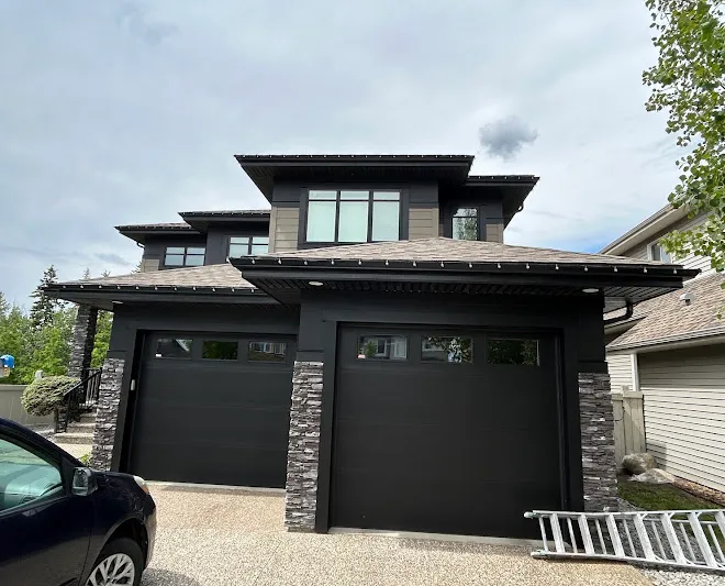 Modern two-storey home with freshly painted black garage doors and trim — Leonard’s Painting, Edmonton area