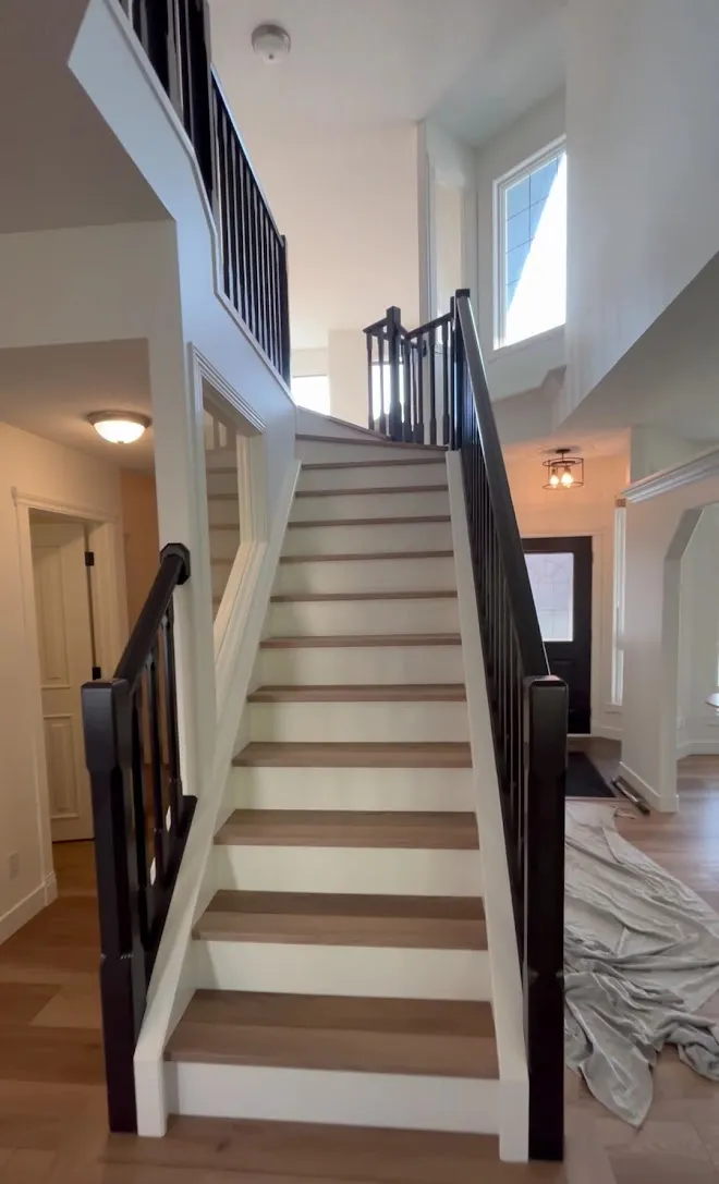 Repainted stairwell with crisp lines along the railing — Leonard’s Painting, Edmonton area