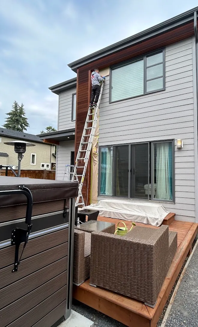 Repainted siding and exterior trim, masked and prepped mid-project — Leonard’s Painting, Edmonton area