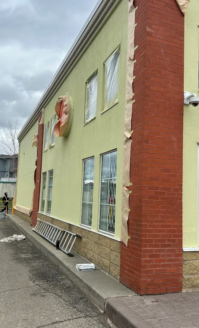 Commercial building exterior during a repaint, masked and prepped — Leonard’s Painting, Edmonton area
