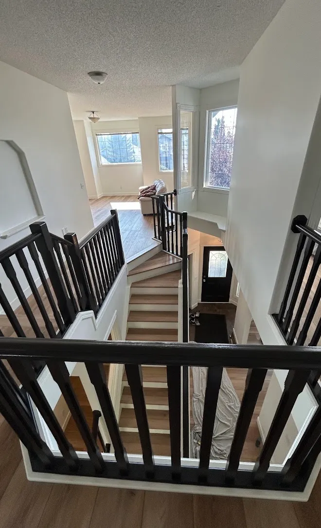 Repainted stairwell with crisp lines along the railing — Leonard’s Painting, Edmonton area