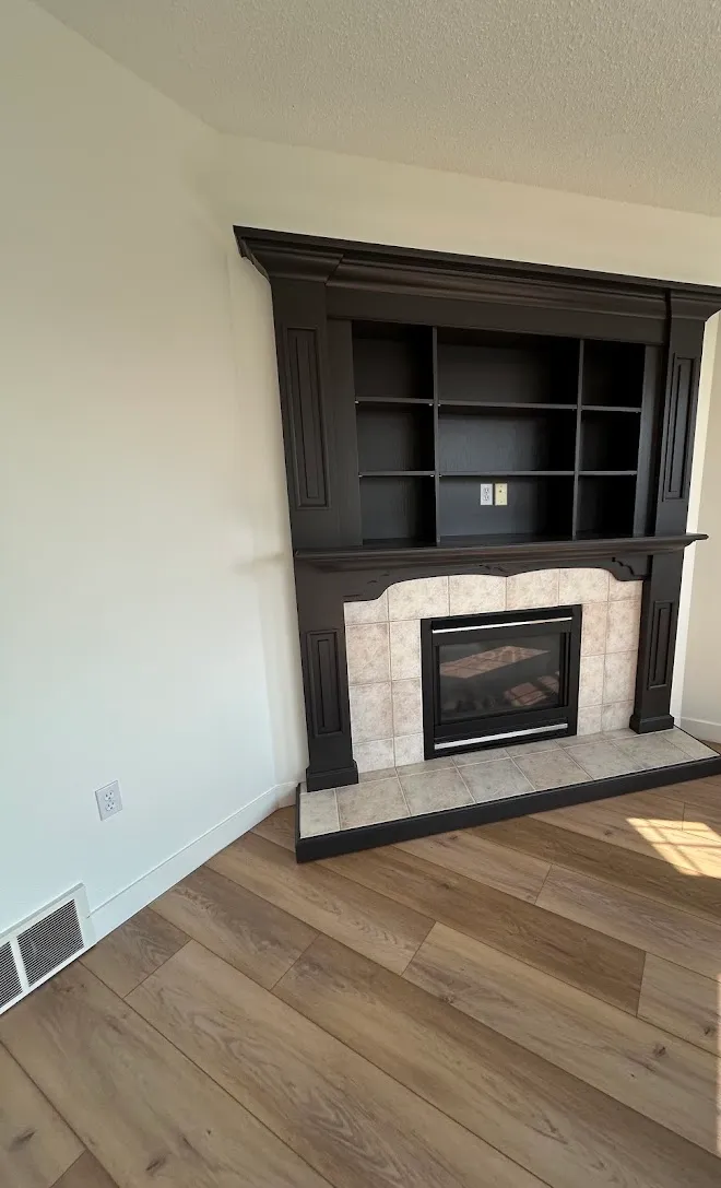 Dark-finished built-in bookcase and fireplace surround — Leonard’s Painting, Edmonton area