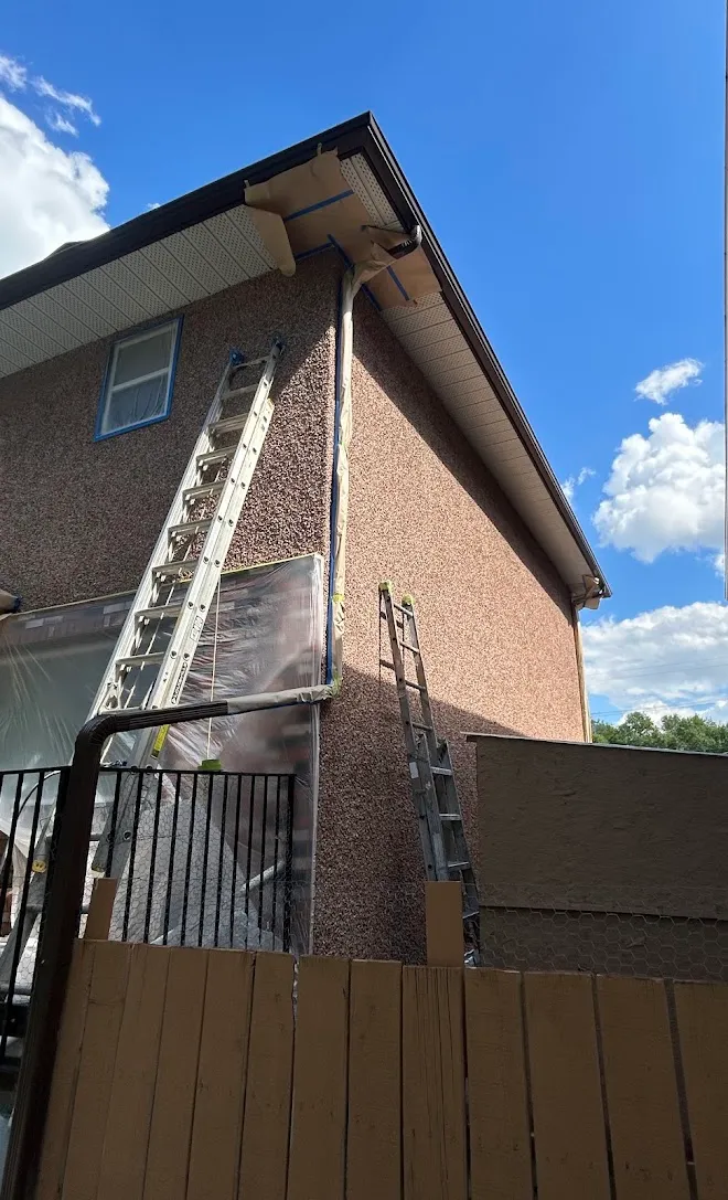 Repainted siding and exterior trim, masked and prepped mid-project — Leonard’s Painting, Edmonton area