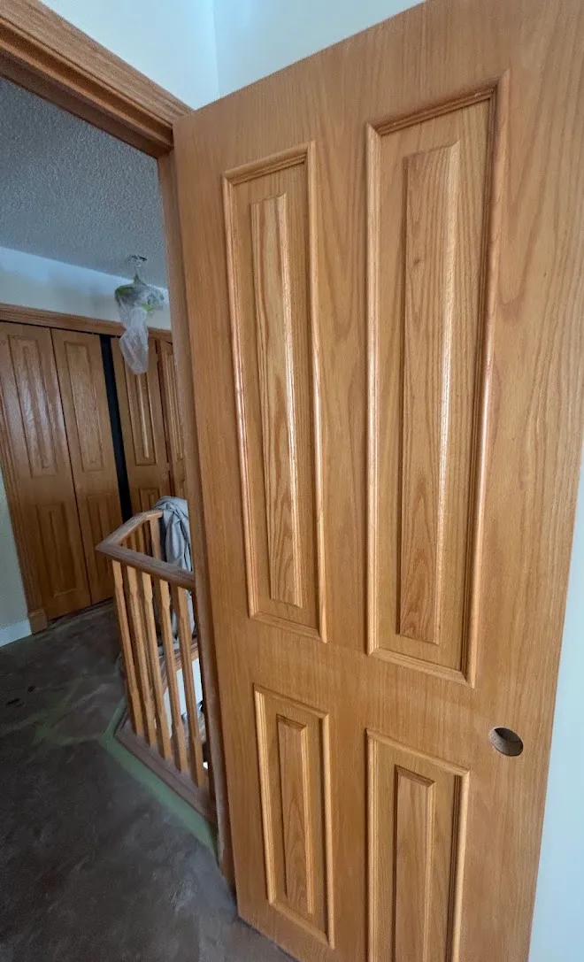 Interior wood door with a clear natural finish — Leonard’s Painting, Edmonton area