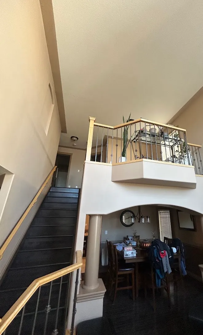 Repainted stairwell with crisp lines along the railing — Leonard’s Painting, Edmonton area